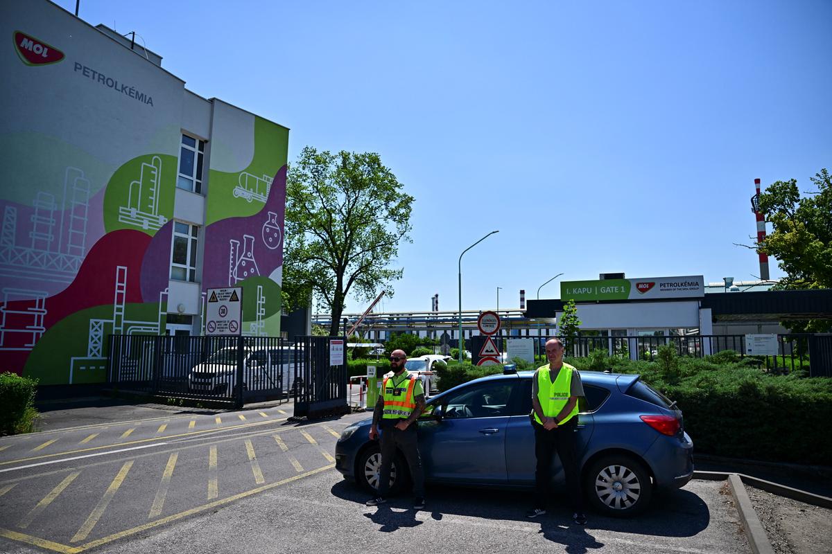 Emergency personnel stand guard outside the gate to the MOL petrochemical plant, where an explosion occurred, in Tiszaujvaros, Hungary, May 22, 2026. REUTERS/Marton Monus