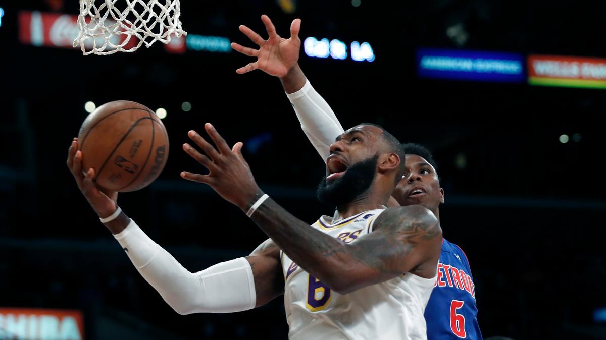 Los Angeles Lakers forward LeBron James, left, gets past to shoot against Detroit Pistons guard Hamidou Diallo, right, during the first half of an NBA basketball game Sunday, Nov. 28, 2021, in Los Angeles. (AP Photo/Alex Gallardo)