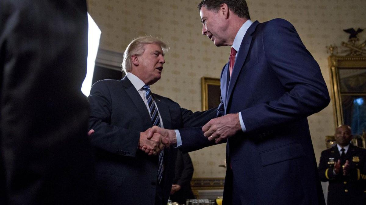 U.S. President Donald Trump (L) shakes hands with James Comey, director of the FBI during in the Blue Room of the White House in Washington, D.C., on January 22, 2017. On May 9, 2017, Trump fired Comey citing mistakes he allegedly made in the investigation into Hillary Clinton's emails. File Photo by Andrew Harrer/UPI