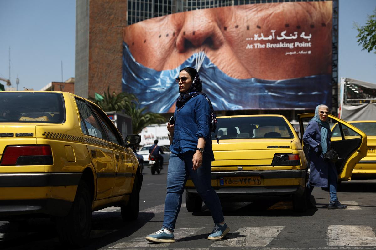 A woman walks past an anti-U.S. billboard depicting U.S. President Donald Trump and the Strait of Hormuz, in Tehran, Iran, May 11, 2026. Majid Asgaripour/WANA (West Asia News Agency) via REUTERS