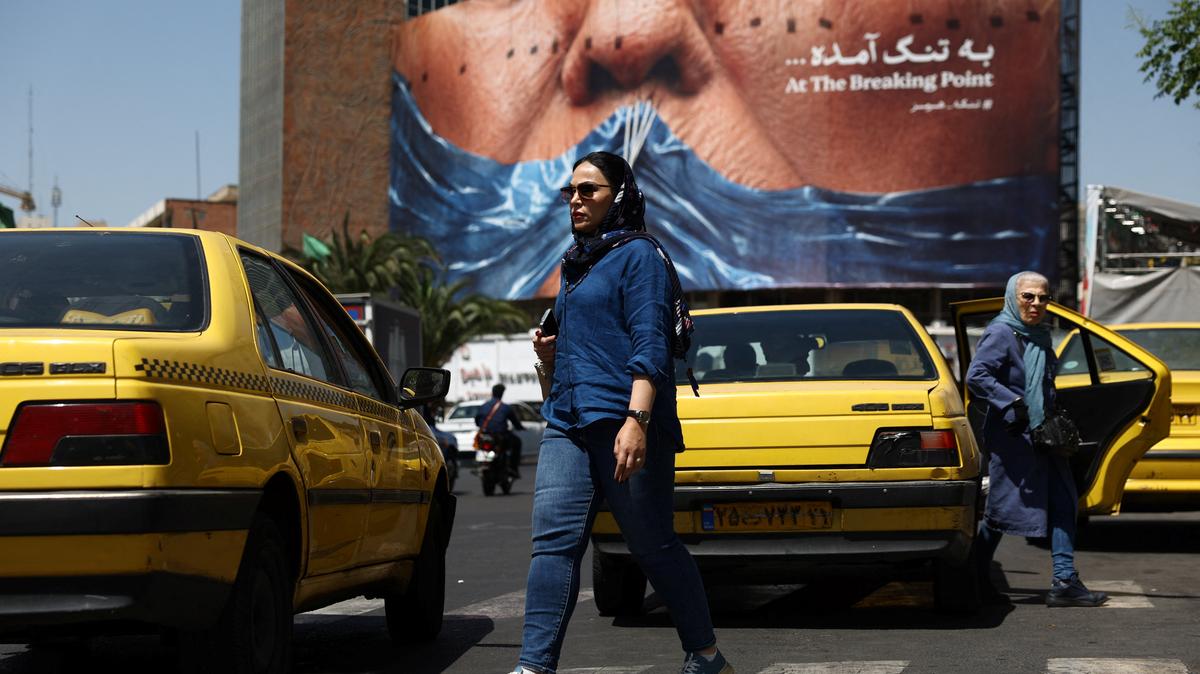 A woman walks past an anti-U.S. billboard depicting U.S. President Donald Trump and the Strait of Hormuz, in Tehran, Iran, May 11, 2026. Majid Asgaripour/WANA (West Asia News Agency) via REUTERS
