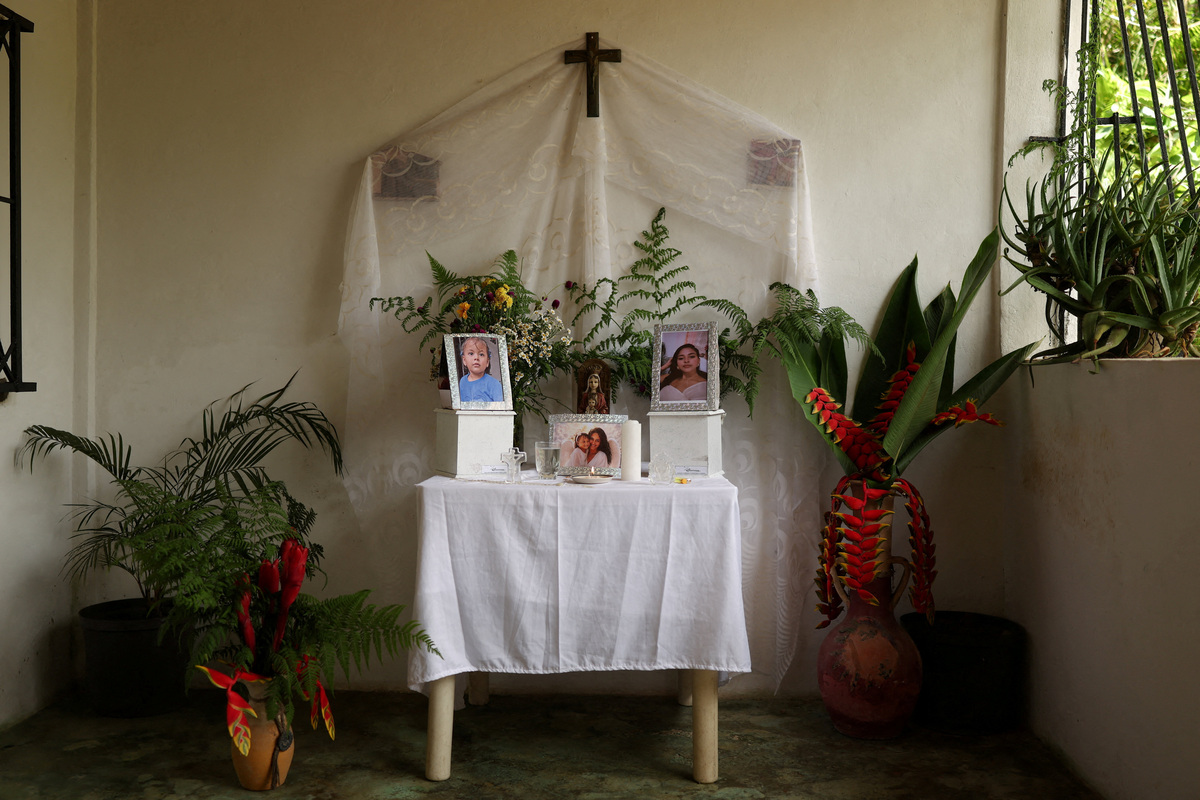 Portraits and boxes containing the ashes of Ashley Martinez and her daughter Kalani Martinez, who were victims of the June 24 earthquakes, stand on a table at the house of Ashley's mother, Juana Aiskel Fumero, in La Guaira, Venezuela, July 6, 2026. REUTERS/Pablo Sanhueza 