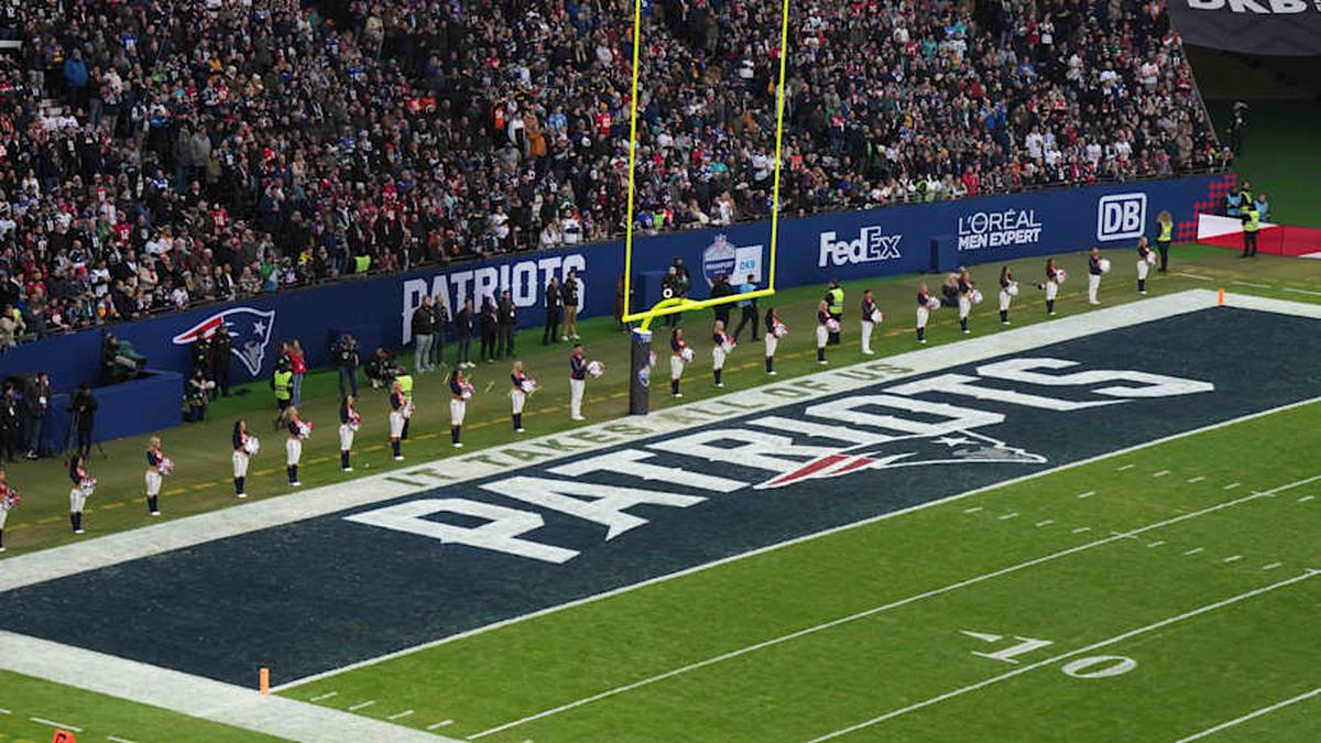  Nov 12, 2023; Frankfurt, Germany; New England Patriots cheerleaders observe the playing of the national anthem in the end zone with a Patriots logo during an NFL International Series game against the Indianapolis Colts at Deutsche Bank Park. Mandatory Credit: Kirby Lee-Imagn Images | Kirby Lee-Imagn Images 