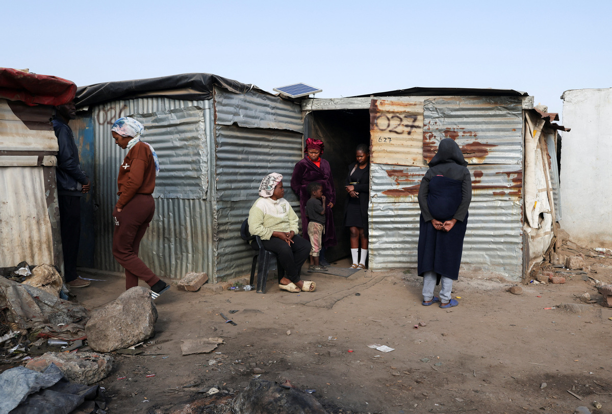 Locals look on near the scene after, according to the police, gunmen opened fire at an informal settlement in Cleveland, Johannesburg, South Africa,  June 10, 2026. REUTERS/Siphiwe Sibeko