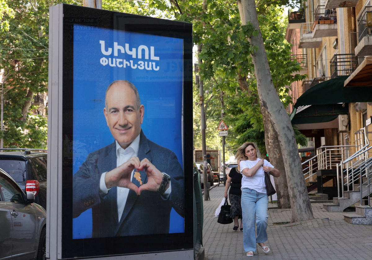 FILE PHOTO: People walk past campaign banners with portraits of Prime Minister Nikol Pashinyan of the Civil Contract party, ahead of the June 7 parliamentary election, in Yerevan, Armenia June 3, 2026. Hayk Baghdasaryan/Photolure via REUTERS/File Photo