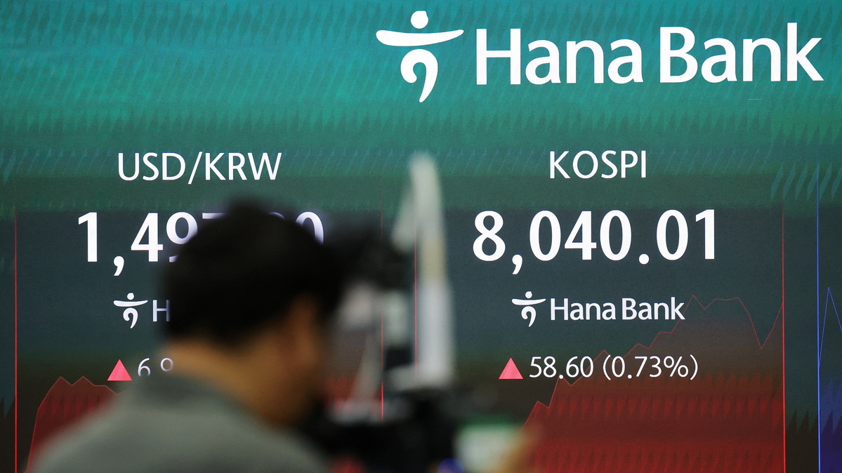 A member of the media prepares to report as an electronic board displays the Korea Composite Stock Price Index (KOSPI) and the exchange rate between the U.S. dollar and the South Korean won, at the dealing room of a bank in Seoul, South Korea, May 15, 2026.   REUTERS/Kim Hong-Ji