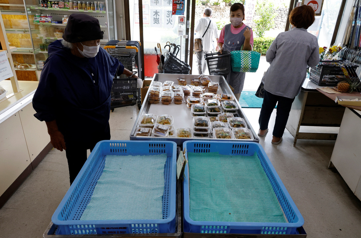 Customers look around the shelves to buy food at a local supermarket, Happy Mart Honna, as Typhoon Bavi approaches in Ishigaki, Japan, July 10, 2026. REUTERS/Kim Kyung-Hoon