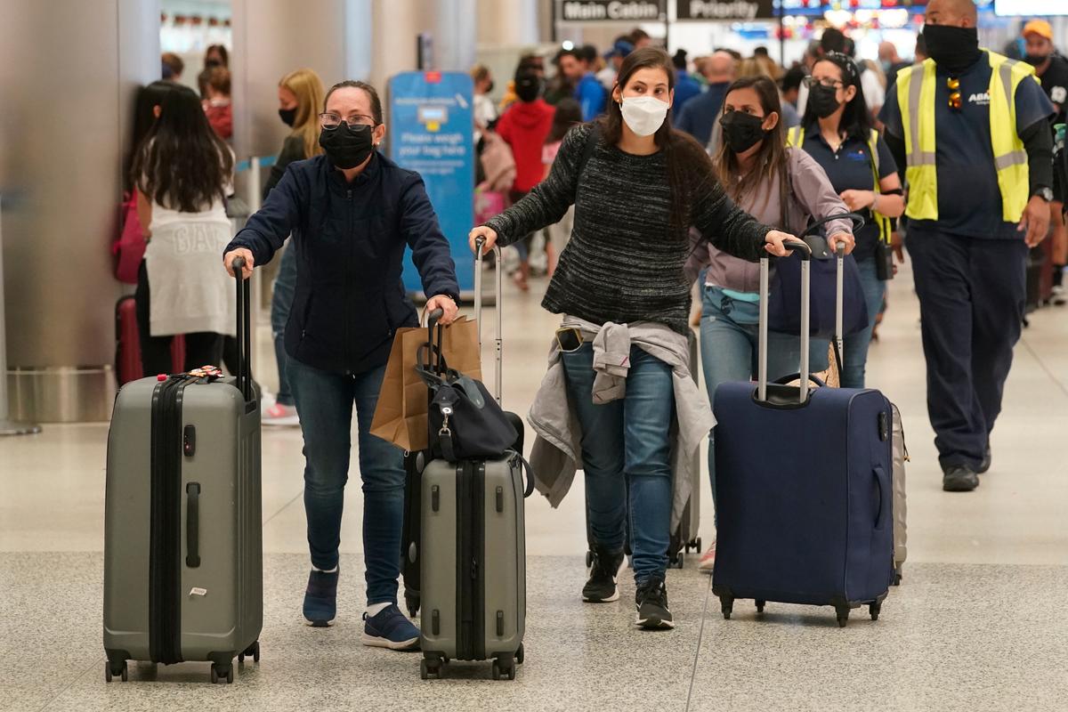 Los pasajeros se apresuran a facturar su equipaje en el Aeropuerto Internacional de Miami el martes 4 de enero de 2022 en Miami.