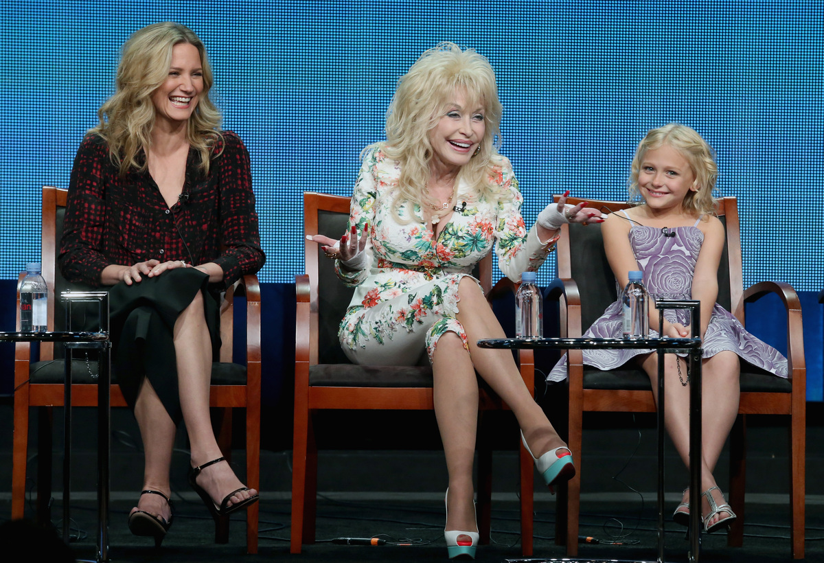 (L-R) Actress Jennifer Nettles, executive producer Dolly and actress Alyvia Alyn Lind speak onstage during NBC’s ‘Dolly Parton’s Coat of Many Colors’ movie panel discussion. (2015)Photo by Frederick M. Brown/Getty Images