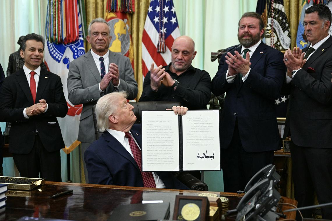  Left to right, Food and Drug Administration Commissioner Marty Makary; Health and Human Services Secretary Robert F. Kennedy Jr.; podcaster Joe Rogan; W. Bryan Hubbard, CEO of Americans for Ibogaine; and former Navy SEAL Marcus Lutrell applaud after President Donald Trump signed an executive order in the Oval Office of the White House in Washington, D.C., on April 18. The executive order aims to further U.S. federal medical research and clinical trials for certain psychedelic drugs. (Photo by Jim Watson/AFP via Getty Images) 