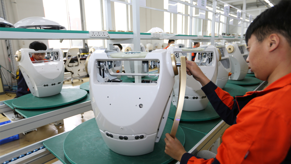 Workers assemble robots at the production line of Chuangze Intelligent Robot in Rizhao, Shandong province, China April 29, 2019. REUTERS/Stringer