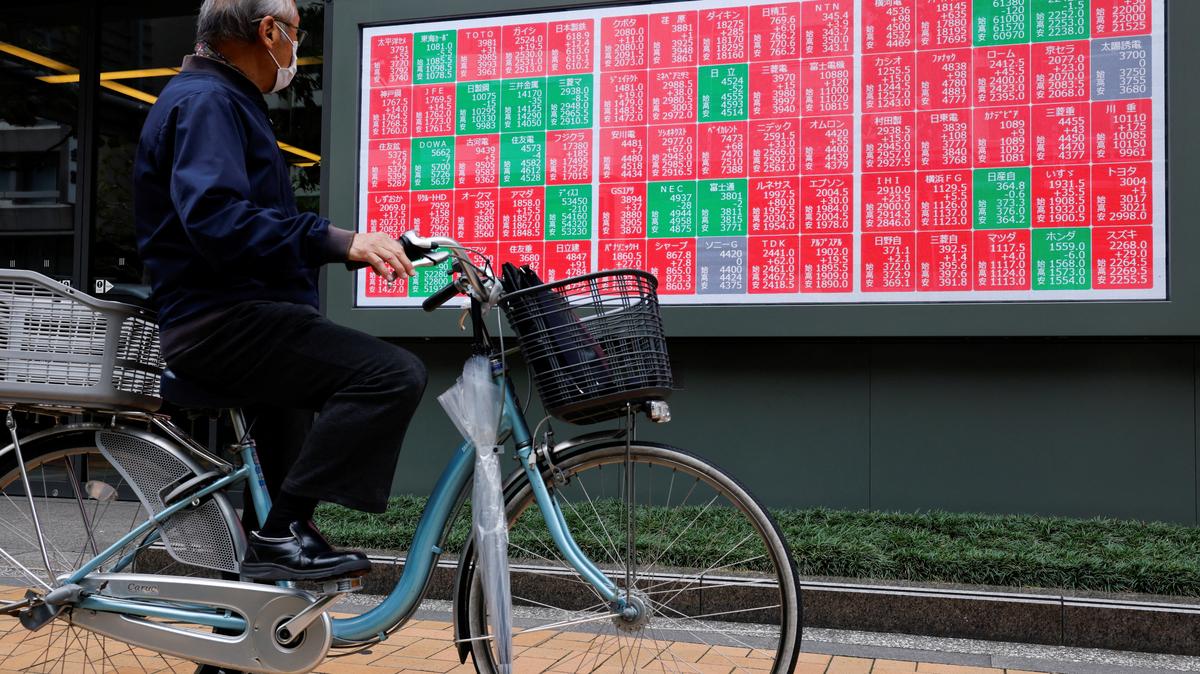 A man looks at a stock quotation board displaying the Nikkei share average outside a brokerage in Tokyo, Japan, October 21, 2025. REUTERS/Manami Yamada