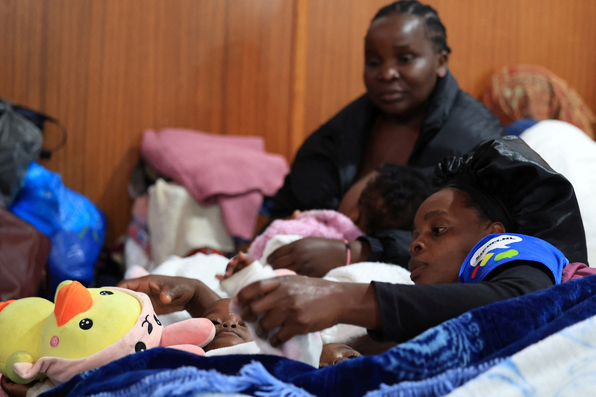 A displaced migrant shelters in a hall with her children, following an escalation in anti-immigrant protests which heightened fears among foreign communities, in Kleinmond, South Africa, June 3, 2026. REUTERS/Esa Alexander