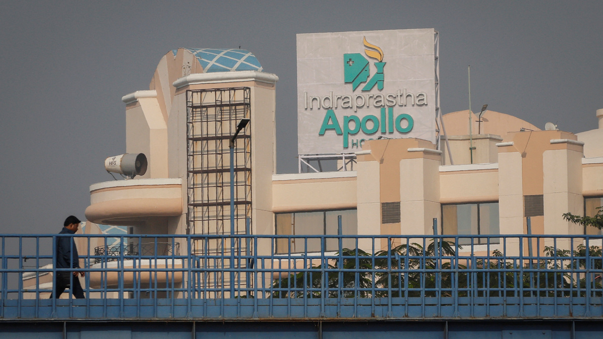 A man walks on a pedestrian bridge in front of an Apollo hospital building in New Delhi, India, December 6, 2023. REUTERS/Adnan Abidi
