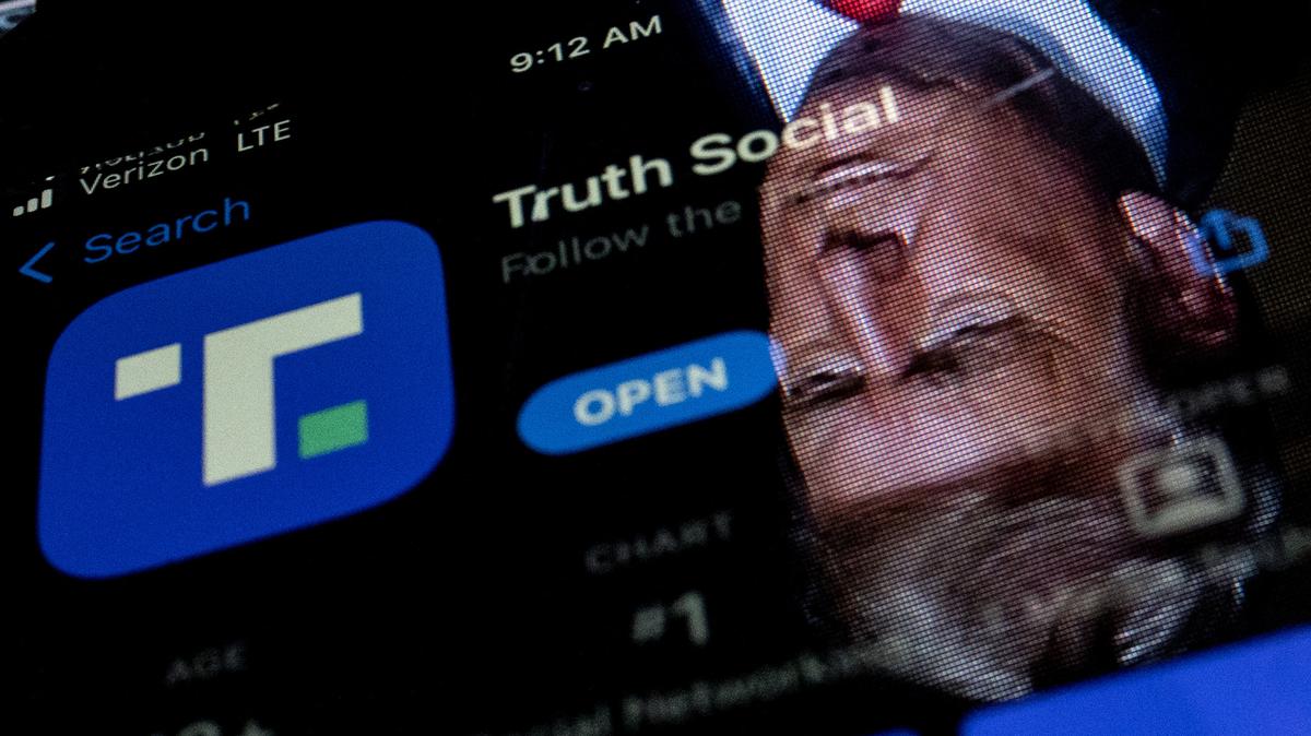 Former President Donald Trump reflected in a phone screen displaying the Truth Social app, in Washington, D.C., on Feb. 21, 2022. (Stefani Reynolds/AFP/Getty Images/TNS)