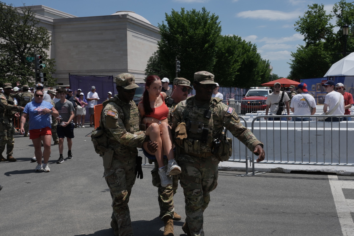 National Guard personnel help an attendee on the verge of fainting, amid celebrations of the 250th anniversary of the United States in Washington, July 4, 2026. America celebrates the 250th anniversary of its independence today, with people from one end of the country to the other marking the milestone with fireworks, parades and concerts. (Alex Kent/The New York Times)