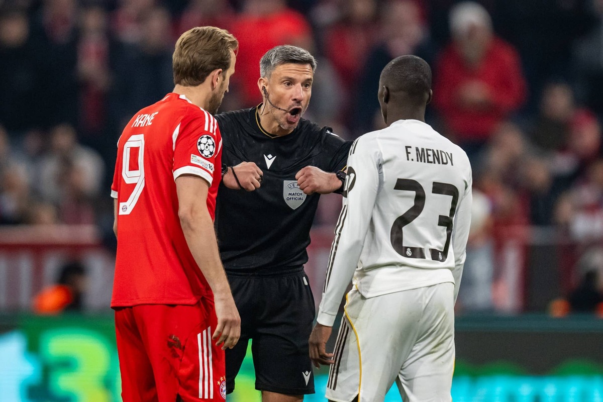  MUNICH, GERMANY - APRIL 15: Referee Slavko Vincic speaks to Harry Kane of FC Bayern Muenchen and Ferland Mendy of Real Madrid during the UEFA Champions League 2025/26 Quarter-Final Second Leg match between FC Bayern München and Real Madrid CF at Football Arena Munich on April 15, 2026 in Munich, Germany. (Photo by Kevin Voigt/GettyImages)