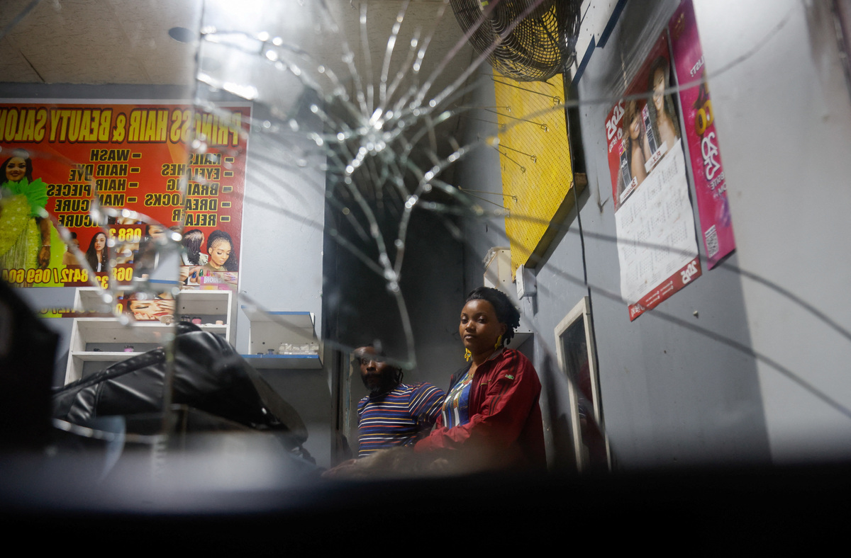 33-year-old Princess Adjei sits inside her salon, which was destroyed in a xenophobic attack on May 18, in Durban, South Africa, June 9, 2026. REUTERS/Rogan Ward