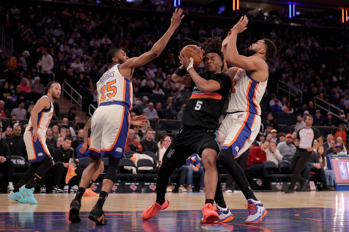  Mar 1, 2026; New York, New York, USA; San Antonio Spurs guard Stephon Castle (5) controls the ball against New York Knicks guard Mikal Bridges (25) and center Karl-Anthony Towns (32) during the third quarter at Madison Square Garden. Mandatory Credit: Brad Penner-Imagn Images 