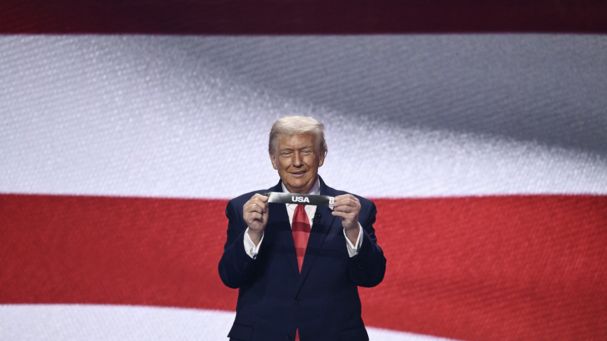 U.S. President Donald Trump shows the card reading "USA" during the draw for the 2026 FIFA Football World Cup taking place in the U.S., Canada and Mexico, at the Kennedy Center, in Washington, D.C., on Dec. 5, 2025. (Brendan Smialowski/AFP via Getty Images/TNS)
