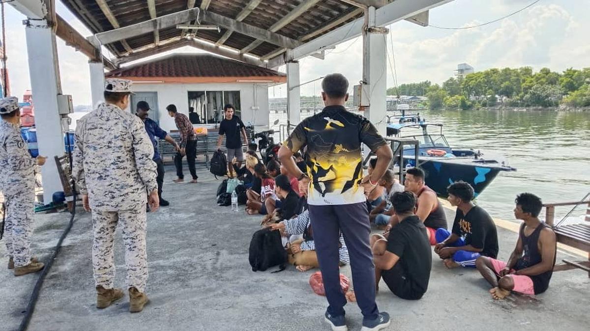 Survivors who were rescued sit after a boat believed to be carrying undocumented Indonesian migrants sank off the coast of Pangkor Island, Malaysia in this undated handout released May 12, 2026. Malaysian Maritime Enforcement Agency/Handout via Reuters
