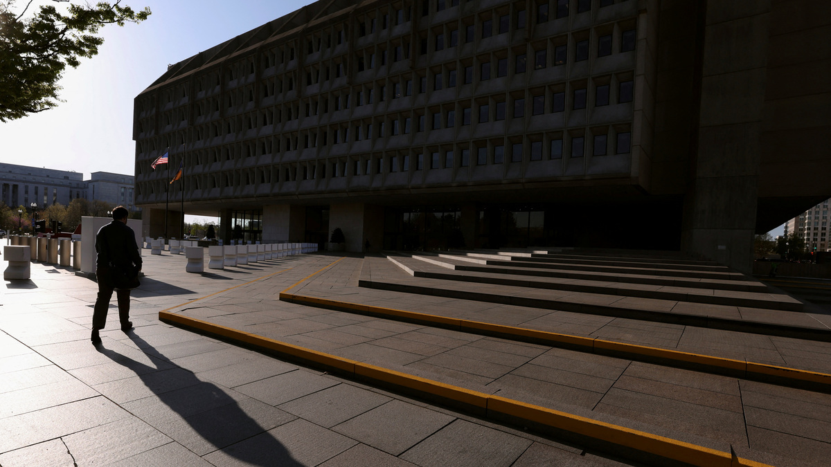 A man casts a shadow as he walks toward the Hubert H. Humphrey Building, headquarters of the  Department of Health and Human Services (HHS) in Washington, D.C., U.S., April 1, 2025. REUTERS/Kevin Lamarque