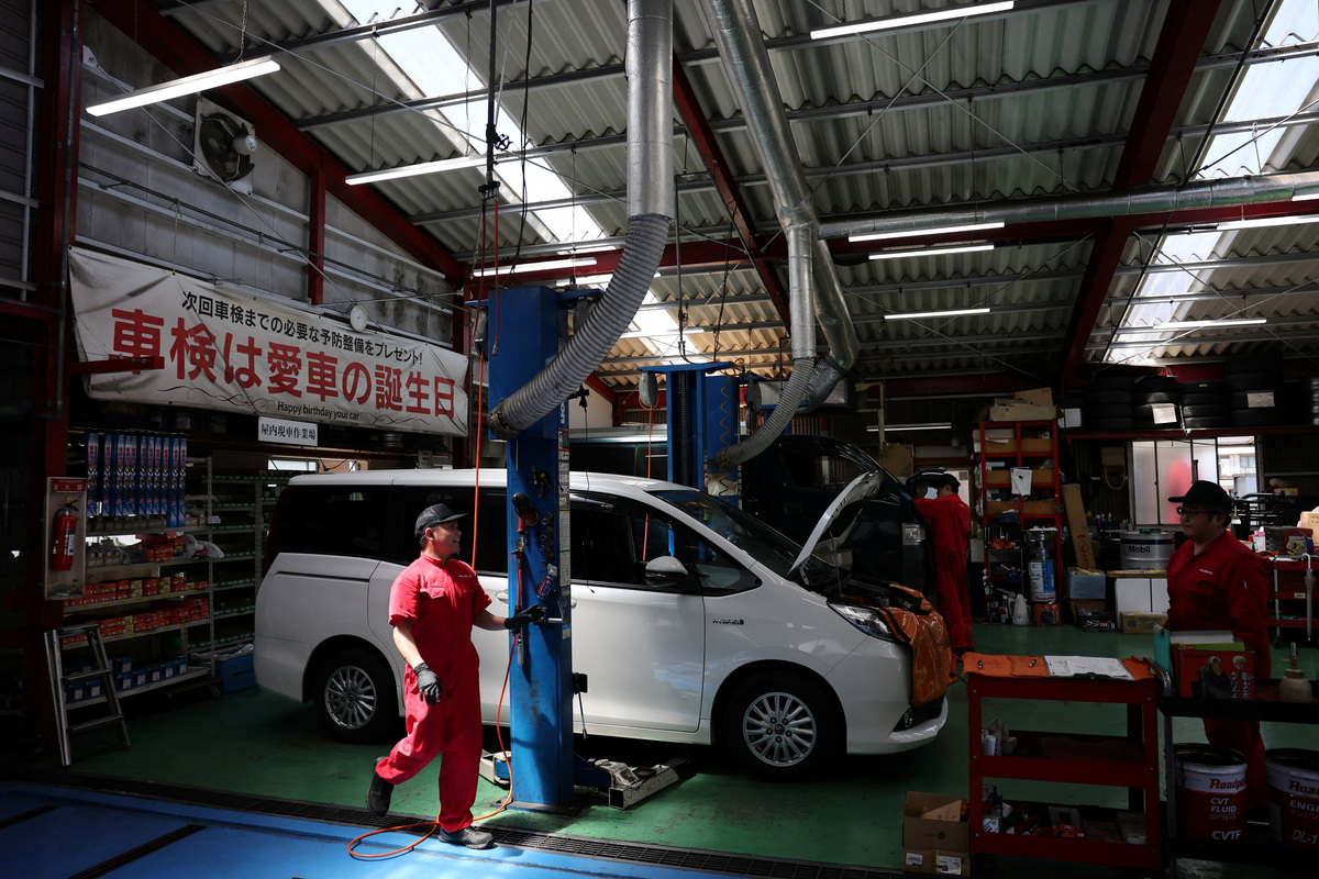 Employees of Fuchu Car, a repair shop that handles accident repairs as well as regular inspections, work next to vehicles at their workshop in Tokyo, Japan May 29, 2026. REUTERS/Issei Kato