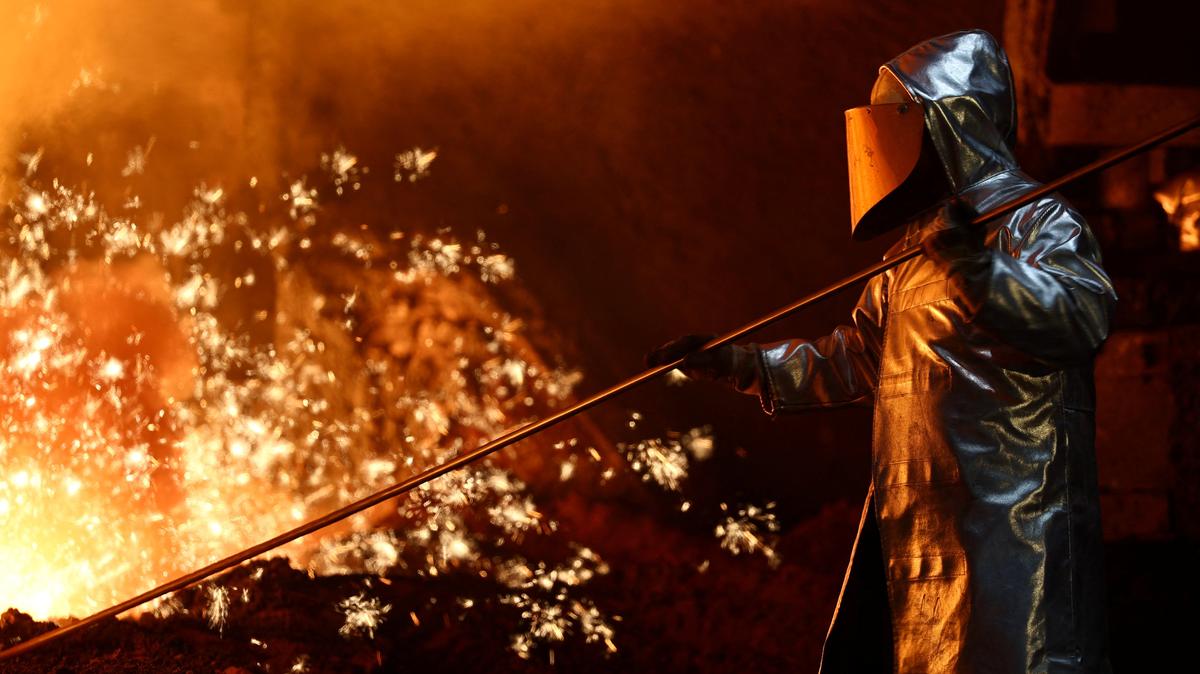 A steel worker stands amid sparks of raw iron coming from a blast furnace at a ThyssenKrupp steel factory in Duisburg, Germany, November 5, 2025. REUTERS/Leon Kuegeler