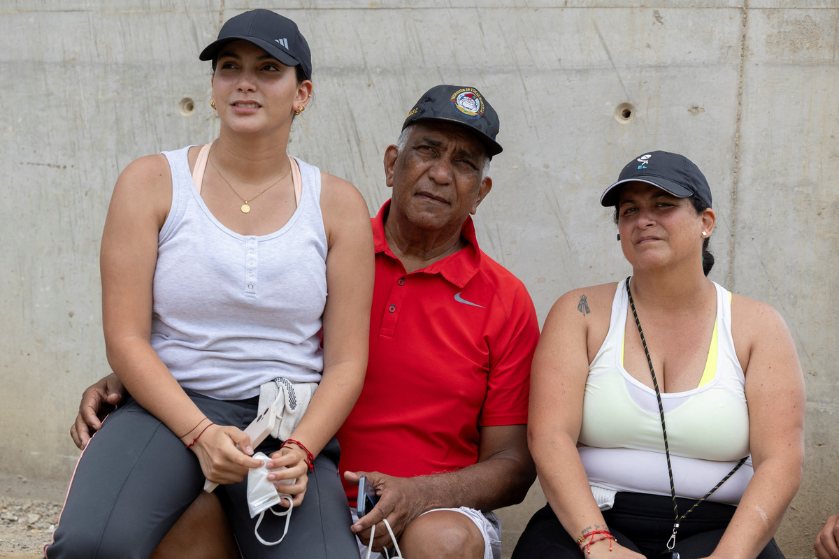 Maria Alejandra Sanz, 17, sits with her father, Alejandro Sanz, and her mother, Maria Sanz, near the remains of their apartment building in La Guaira, Venezuela, July 5, 2026. REUTERS/Ricardo Arduengo