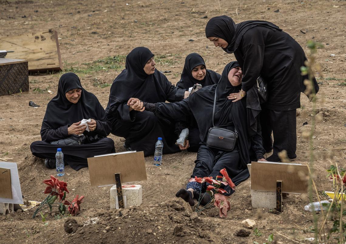 Women comfort Suheila, second from right, as she grieves over a temporary grave for her son, who was a fighter with Hezbollah, at a cemetery in Tyre, Lebanon, April 18, 2026. Gathering at the cemetery for the first time since the ceasefire, they hope to relocate the remains to their now accessible home villages. (David Guttenfelder/The New York Times)