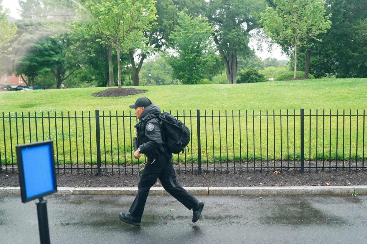 A U.S. Secret Service agent runs after alleged gunshots were heard nearby, at the White House in Washington, D.C., U.S., May 23, 2026. REUTERS/Nathan Howard