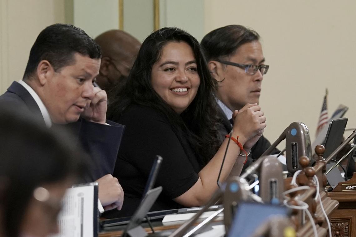 Assemblywoman Wendy Carrillo, D-Los Angeles, center, smiles after her bill was approved by the Assembly at the Capitol in May. Carrillo, who grew up speaking Spanish at home, often translates to help non-English-speakers participate in civic life.