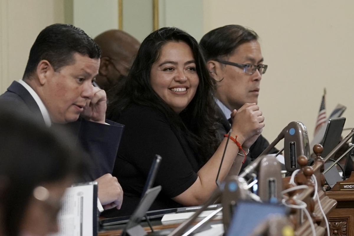 Assemblywoman Wendy Carrillo, D-Los Angeles, center, smiles after her bill was approved by the Assembly at the Capitol in May. Carrillo, who grew up speaking Spanish at home, often translates to help non-English-speakers participate in civic life.