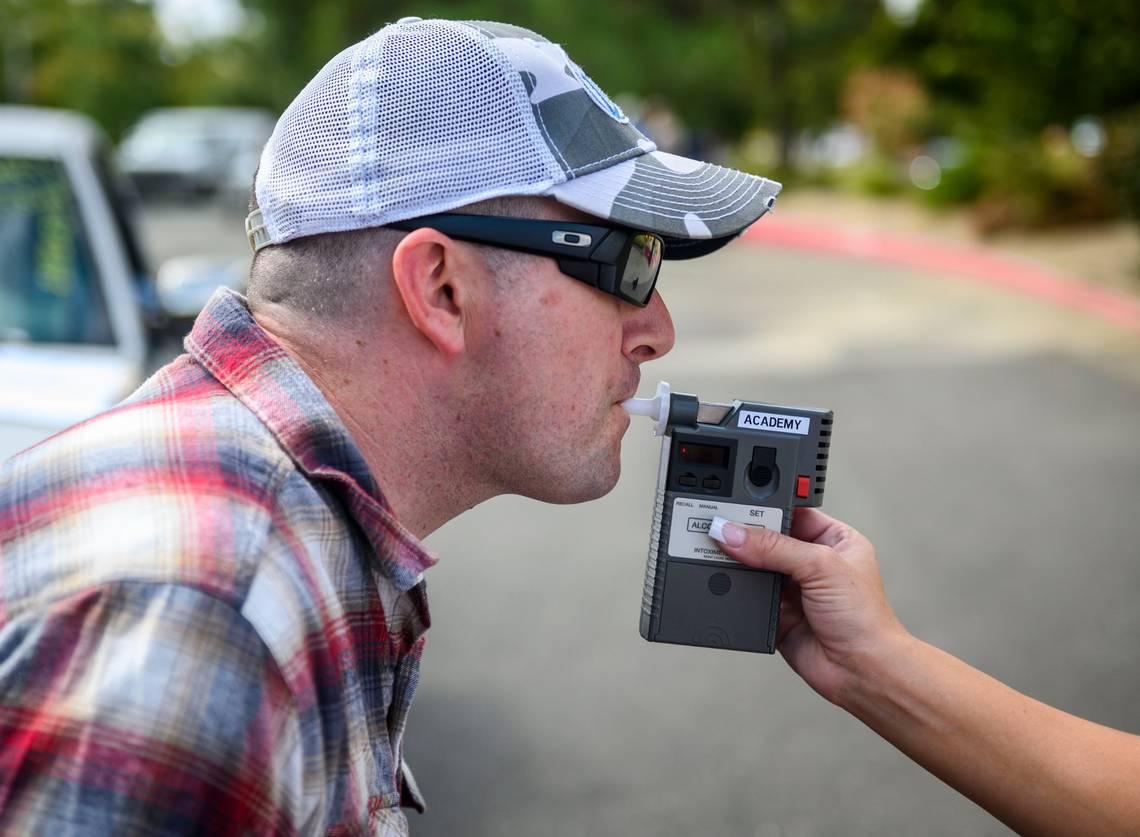 California Highway Patrol officer Mike Maher blows into a breath analyzer during a DUI investigation simulation during a media boot camp at the CHP academy in West Sacramento, California, on Sept. 18, 2019.