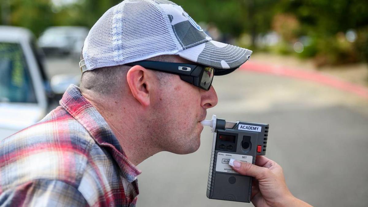 California Highway Patrol officer Mike Maher blows into a breath analyzer during a DUI investigation simulation during a media boot camp at the CHP academy in West Sacramento, California, on Sept. 18, 2019. (Daniel Kim/The Sacramento Bee/TNS)