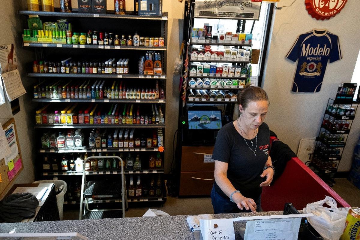 Tonyah Bruyette checks out a customer at the liquor store where she works in Wiggins, Colorado, U.S., May 11, 2026.  REUTERS/Kevin Mohatt