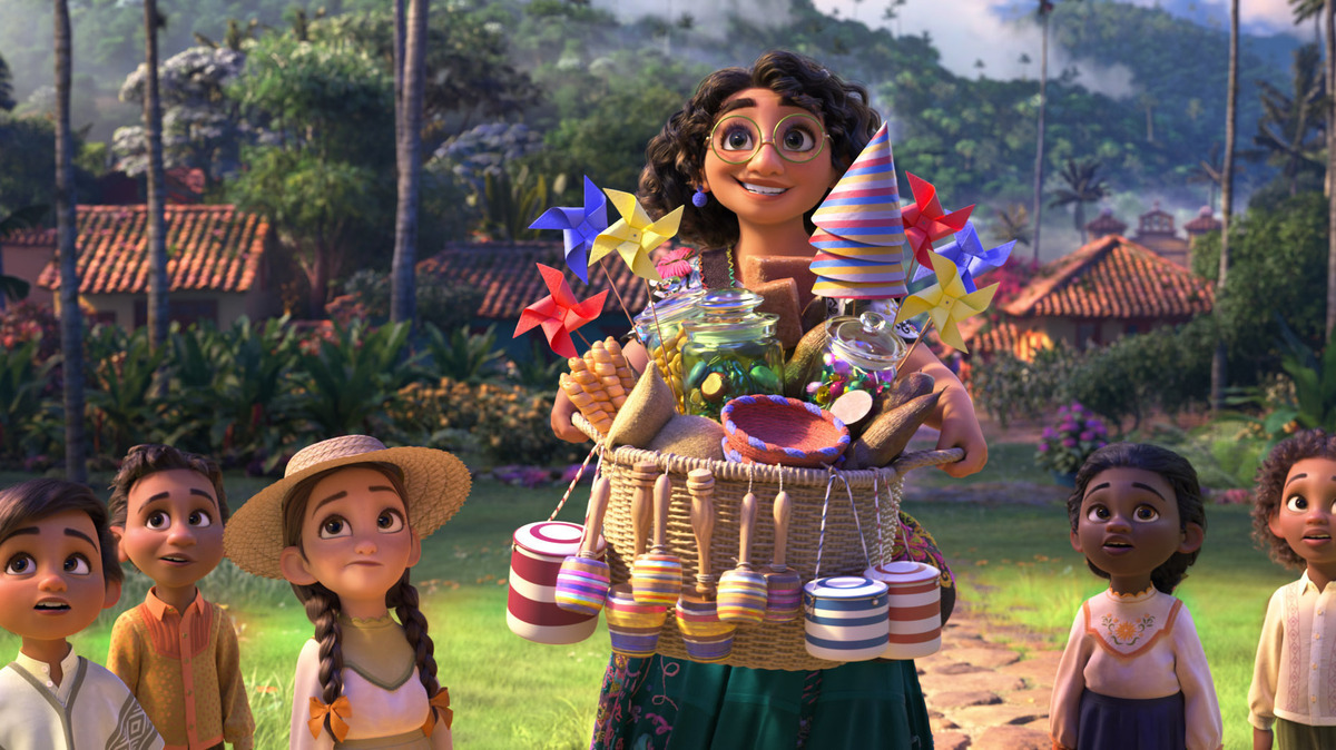 En esta imagen difundida por Disney, el personaje de Mirabel, en el centro, cuya voz en inglés hace Stephanie Beatriz, en una escena de la película animada “Encanto”. (Disney vía AP)