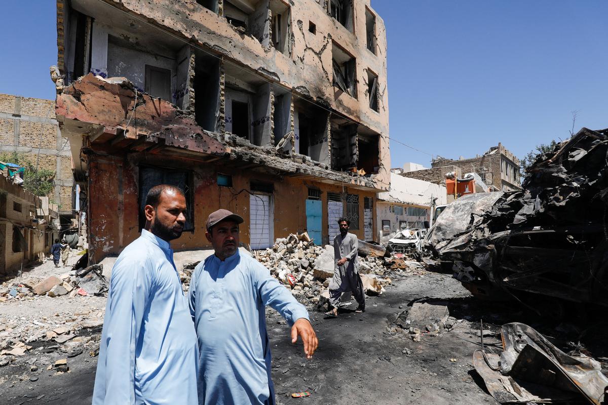 Residents stand next to a damaged building, rubble and destroyed cars a day after a blast in Quetta, Pakistan May 25, 2026. REUTERS/Naseer Ahmed