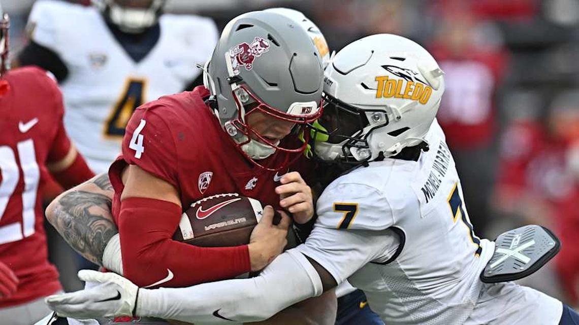  Oct 25, 2025; Pullman, Washington, USA; Washington State Cougars quarterback Zevi Eckhaus (4) is tackled by Toledo Rockets safety Emmanuel McNeil-Warren (7) in the second half at Gesa Field at Martin Stadium. Mandatory Credit: James Snook-Imagn Images | James Snook-Imagn Images 