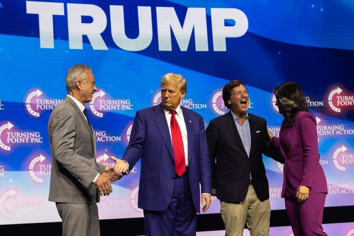 President Donald Trump greets, from left, Robert F. Kennedy Jr., conservative commentator Tucker Carlson, and Tulsi Gabbard on stage during his campaign rally at Gas South Arena in Duluth, Georgia, on Oct. 23, 2024. Kennedy now runs the Department of Health and Human Services. Gabbard is now director of National Intelligence.