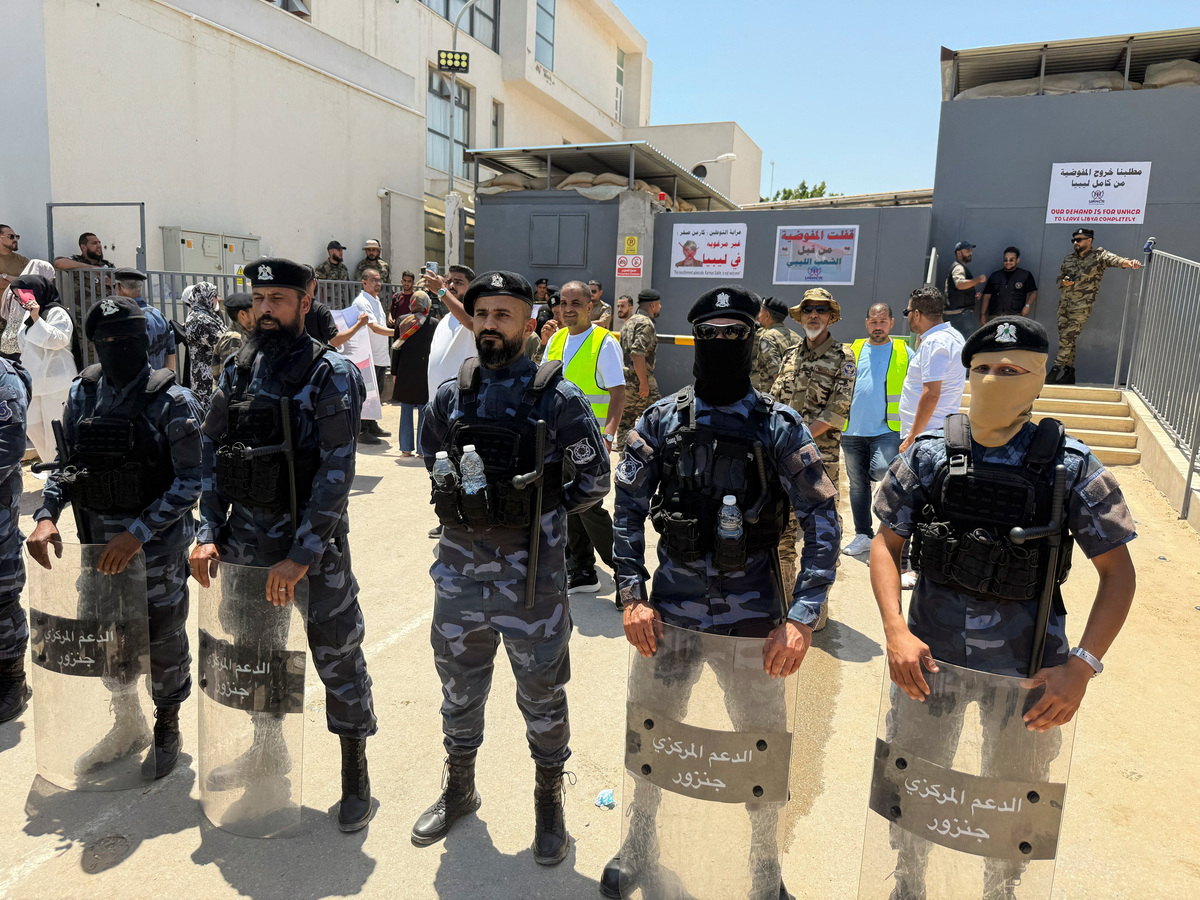 Security personnel stand guard as protesters gather outside the headquarters of the United Nations High Commissioner for Refugees (UNHCR), demanding the organisation leave the country and calling for an end to migrant settlement and the deportation of migrants and refugees, in Tripoli, Libya, June 4, 2026. Picture taken with a mobile phone. REUTERS/Ayman al-Sahili