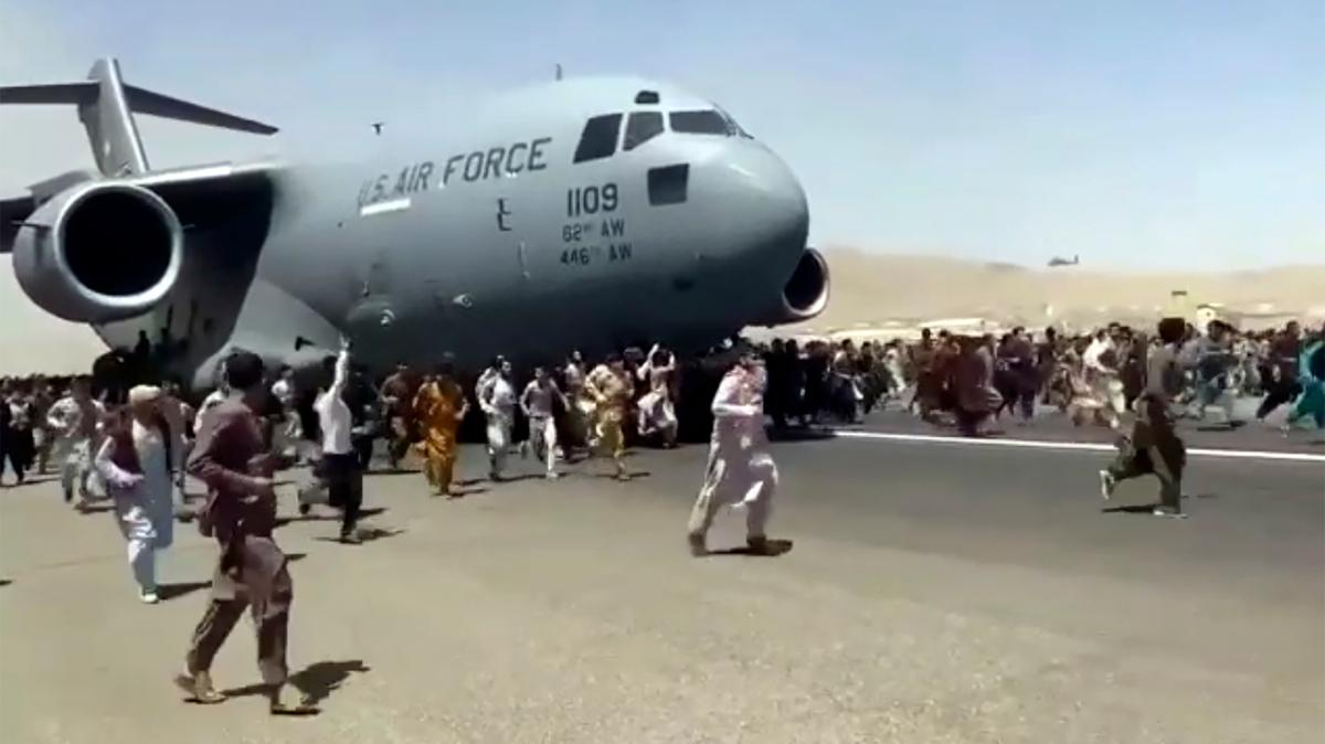 Cientos de personas corren junto a un avión militar de EEUU que se apresta a despegar en el aeropuerto de Kabul el lunes 16 de agosto del 2021, tras la toma del poder por parte del Talibán. (Verified UGC vía AP)