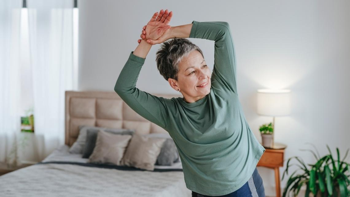 Smiling woman stretching at home