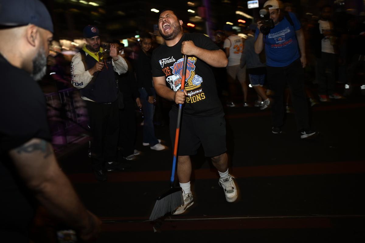 Jubilant Knicks fans celebrate outside Madison Square Garden in New York after their team swept the Cleveland Cavaliers in the Eastern Conference Finals to advance to the NBA Finals for the first time since 1999 on Monday night, May 25, 2026. Thousands of fans blocked traffic outside Madison Square Garden, even though the game was in Ohio and the outdoor watch parties at the Garden had been suspended because of rowdy fans. (Vincent Alban/The New York Times)