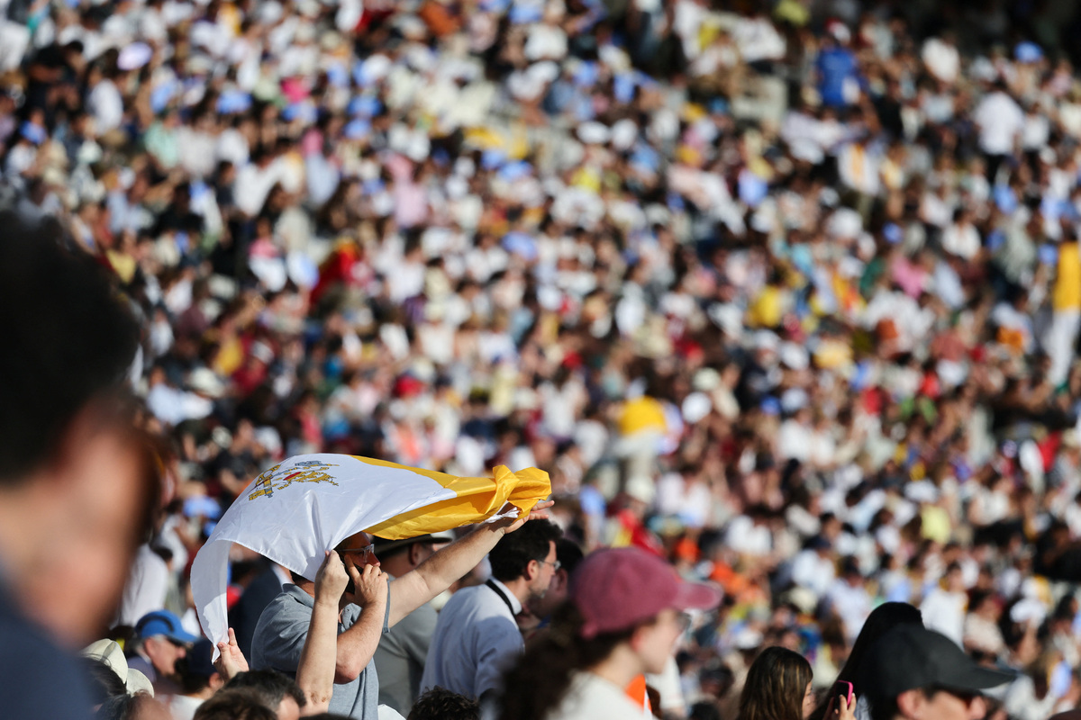 A person holds a Vatican flag as faithful gather ahead of a prayer vigil with Pope Leo XIV at the Lluis Companys Olympic Stadium, during his apostolic journey, in Barcelona, Spain, June 9, 2026. REUTERS/Yara Nardi