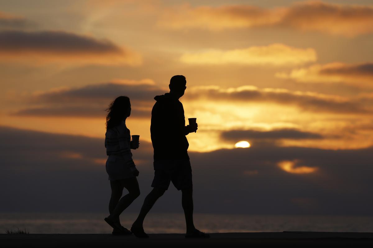  A couple walk along the La Jolla coast at sunset on a warm, summer evening on August 3, 2025 in San Diego, California. 