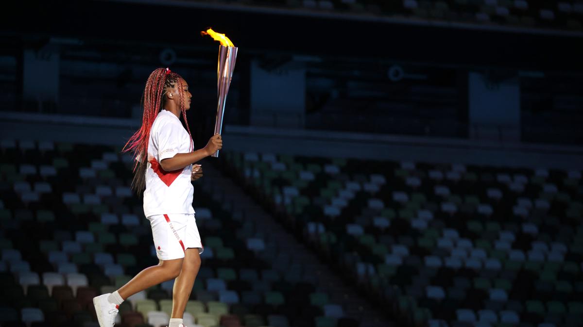 La tenista Naomi Osaka sostiene la antorcha durante la ceremonia de inauguración de los Juegos Olímpicos, el viernes 23 de julio de 2021, en Tokio (Hannah McKay/Pool Photo via AP)