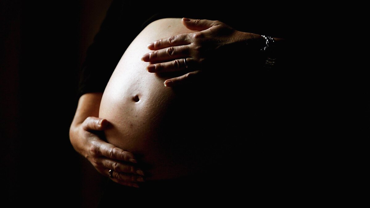 Australia Celebrates Baby Boom. SYDNEY, NSW - JUNE 07:  A pregnant woman holds her stomach June 7, 2006 in Sydney, Australia. Australia is currently enjoying a baby boom, with the Australian Bureau of Statistics registering a 2.4% increase in births from 2004 to 2005, which represents the highest number of births since 1992. The Australian Federal Government has been encouraging people to have more babies, with financial incentives and the slogan by treasurer Peter Costello to "have one for mum, one for dad, and one for the country". The Federal Government has identified falling fertility rates and the ageing population as long-term problems for Australia's growth and prosperity.  (Photo by Ian Waldie/Getty Images)