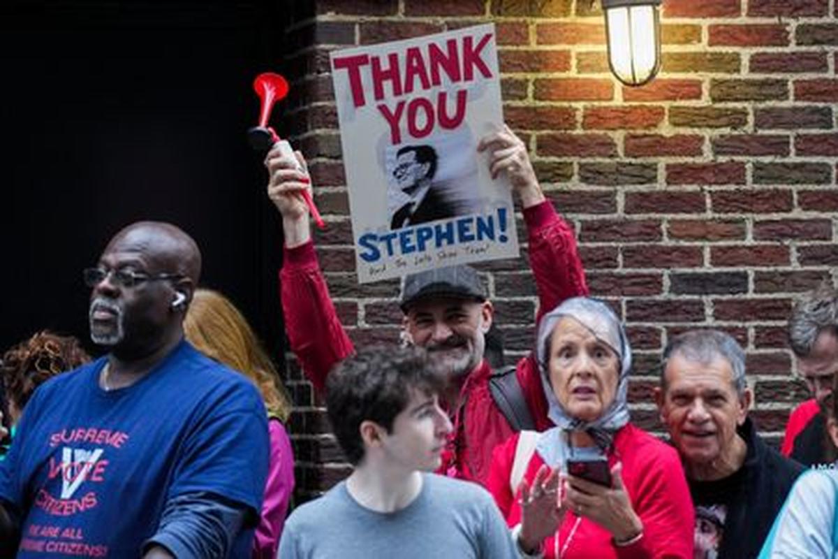 A person holds a sign outside of the Ed Sullivan Theater where the last show of Stephen Colbert’s Late Show is filmed, in New York City, U.S., May 21, 2026. REUTERS/Adam Gray