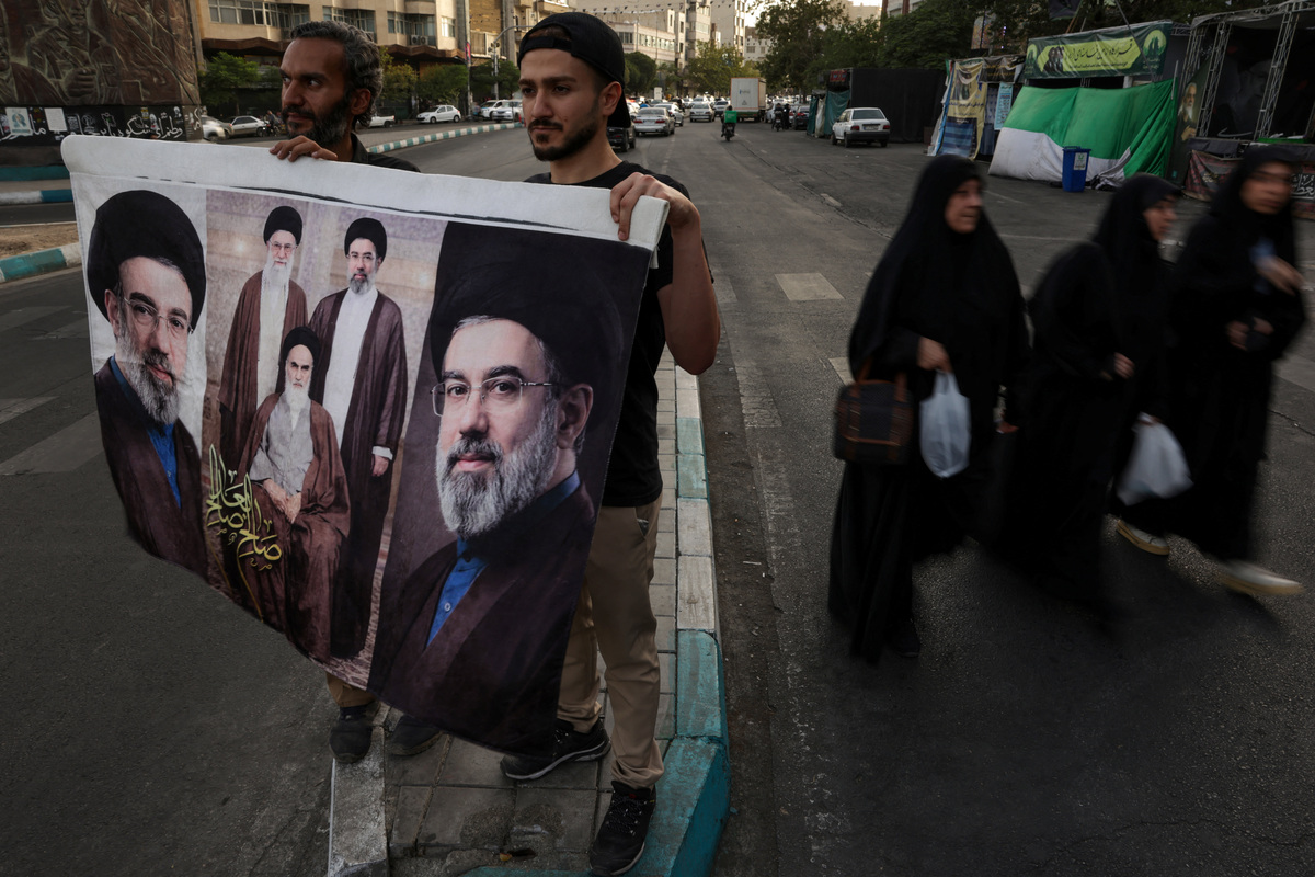 Men hold a banner depicting Iran's late leader Ayatollah Ruhollah Khomeini, Iran's late Supreme Leader Ayatollah Ali Khamenei and Iran's Supreme Leader Ayatollah Mojtaba Khamenei at Revolution Square ahead of a night rally in Tehran, Iran, July 2, 2026. REUTERS/Murad Sezer Foreign media in Iran operate under guidelines set by the Ministry of Culture and Islamic Guidance, which regulates press activity and permissions